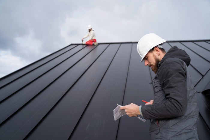 professional roofing contractor inspecting and installing metal roof for residential building